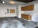 Two-car garage featuring concrete floors, storage cabinets, and door to home at 5519 Fall Creek Rd, Indianapolis, IN 46220