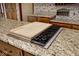 Granite kitchen island featuring a built-in grill and ample counter space at 5519 Fall Creek Rd, Indianapolis, IN 46220