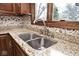 Close-up of kitchen sink with granite countertops and a window view at 5519 Fall Creek Rd, Indianapolis, IN 46220