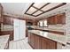 Traditional kitchen showcasing granite countertops, wooden cabinets, a central island, and modern appliances at 5519 Fall Creek Rd, Indianapolis, IN 46220