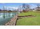 Serene view of well-manicured lawn, waterside access, and a tranquil lake, enhancing the property's appeal at 5519 Fall Creek Rd, Indianapolis, IN 46220