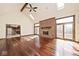 Spacious living room featuring hardwood floors, a brick fireplace, and lots of natural light at 5519 Fall Creek Rd, Indianapolis, IN 46220
