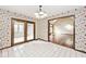 Sun room featuring tiled floors and access to the bright living room with floral wallpaper at 5519 Fall Creek Rd, Indianapolis, IN 46220