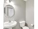 Simple bathroom with a pedestal sink, round mirror, and standard toilet at 61 Larimar Way, Whiteland, IN 46184