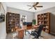 Well-lit home office with large wooden desk, built-in bookshelves, and comfortable office chairs at 61 Larimar Way, Whiteland, IN 46184