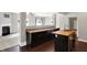 Modern kitchen with dark cabinets, wooden island, and open view to the living area with a fireplace at 61 Larimar Way, Whiteland, IN 46184