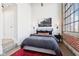 Modern bedroom with a large window, exposed brick, concrete ceiling and stylish decor at 611 N Park Ave # 414, Indianapolis, IN 46204