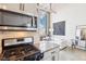 Open kitchen with stainless steel appliances leading to a living space with large windows at 611 N Park Ave # 414, Indianapolis, IN 46204