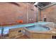 Indoor pool and jacuzzi with exposed brick, steel beam, and tile flooring at 611 N Park Ave # 414, Indianapolis, IN 46204