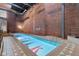 Indoor pool area with exposed brick walls, steel beam, and patterned pool bottom at 611 N Park Ave # 414, Indianapolis, IN 46204