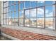 Large window offers beautiful city views, framed by exposed brick and concrete accents at 611 N Park Ave # 414, Indianapolis, IN 46204