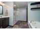 Modern bathroom features a glass shower door, dark cabinets and a separate soaking tub at 6880 W Jennifer Dr, Greenfield, IN 46140