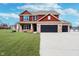 Inviting two-story home boasts brick and red siding, black shutters, and a wide driveway at 6880 W Jennifer Dr, Greenfield, IN 46140