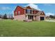 Charming two-story home with brick and red siding with covered porch and green lawn at 6880 W Jennifer Dr, Greenfield, IN 46140