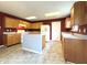 Kitchen with wood cabinetry, center island, and modern white appliances at 6896 Maywood Cir, Avon, IN 46123
