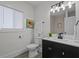 Modern bathroom with sleek black vanity, white toilet, and elegant mirror lighting at 729 W 32Nd St, Indianapolis, IN 46208