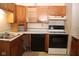 Kitchen with oak cabinets, black appliances, and tile floors at 7625 E 35Th St, Indianapolis, IN 46226