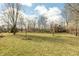 Spacious backyard featuring a lush lawn, bordered by mature trees providing privacy at 7806 Ashtree Dr, Indianapolis, IN 46259