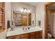 Bathroom featuring a wood vanity, a well-lit mirror, and an open doorway to the bedroom at 7806 Ashtree Dr, Indianapolis, IN 46259