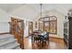 Dining room with high vaulted ceilings and a large window overlooking the yard and hardwood floors at 7806 Ashtree Dr, Indianapolis, IN 46259