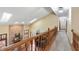 Upstairs hallway overlooking the living area with a brick fireplace and soaring ceilings at 7806 Ashtree Dr, Indianapolis, IN 46259