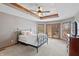 Spacious main bedroom featuring a tray ceiling, fan, neutral colors, and patio access at 7806 Ashtree Dr, Indianapolis, IN 46259