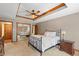Spacious main bedroom with a tray ceiling, fan, neutral colors, carpeted floors and a walk-in mirrored closet at 7806 Ashtree Dr, Indianapolis, IN 46259