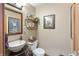 Charming powder room featuring a stylish vessel sink, elegant decor, and a framed art collection at 7806 Ashtree Dr, Indianapolis, IN 46259