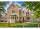 Charming stone home with a beautifully landscaped yard, framed by mature trees and a black metal fence at 906 Franklin St, Columbus, IN 47201