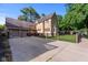 Stunning stone home featuring a spacious driveway and well-manicured lawn behind a black metal fence at 906 Franklin St, Columbus, IN 47201