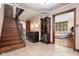 Spacious foyer with hardwood staircase, elegant display cabinet, and views into other rooms, creating an open feel at 906 Franklin St, Columbus, IN 47201