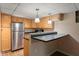 Compact kitchenette with stainless steel refrigerator and breakfast bar seating at 906 Franklin St, Columbus, IN 47201