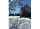A view of the snow-covered backyard with a storage unit and visible footprints leading from the home at 911 W 3Rd St, Anderson, IN 46016