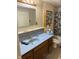 This bathroom features a blue vanity, a large mirror, and a polka dot shower curtain at 911 W 3Rd St, Anderson, IN 46016