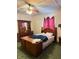 Comfortable bedroom features a ceiling fan, wood furniture, and natural light from the window at 911 W 3Rd St, Anderson, IN 46016
