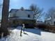 Charming two-story home with a covered front porch and a snow-covered front yard and driveway at 911 W 3Rd St, Anderson, IN 46016