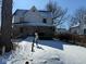 Charming two-story home with a covered front porch and a snow-covered front yard and driveway at 911 W 3Rd St, Anderson, IN 46016