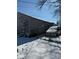 An older garage with peeling paint sits alongside a snow-covered car, both surrounded by a chain-link fence at 911 W 3Rd St, Anderson, IN 46016