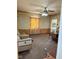 A well-lit living room featuring patterned wallpaper, a ceiling fan, and a comfortable chair at 911 W 3Rd St, Anderson, IN 46016