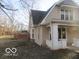 A side view of the charming two-story home highlighting a spacious yard and mature trees at 929 Gilbert Ave, Indianapolis, IN 46227