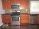 Modern kitchen featuring stainless steel appliances, stone backsplash, and wood cabinets at 929 Gilbert Ave, Indianapolis, IN 46227