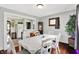 Dining room with a white table set for six, hardwood floors, and an open view to the kitchen at 960 Cameron St, Indianapolis, IN 46203