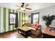 Cozy living room with striped accent wall, ceiling fan, and comfortable seating near two windows at 960 Cameron St, Indianapolis, IN 46203