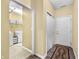 Hallway leading to a laundry room, featuring an exterior door and closet with modern fixtures at 112 Bridgemor Ln, Mooresville, IN 46158