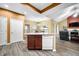 Bright kitchen featuring an island with sink and dishwasher, adjacent to the living room with vaulted ceilings at 112 Bridgemor Ln, Mooresville, IN 46158