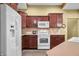 Bright kitchen featuring dark wood cabinetry, stainless steel appliances, and laminate countertops at 112 Bridgemor Ln, Mooresville, IN 46158