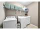 Laundry room showing stacked washer and dryer, tiled floor and storage shelves at 112 Bridgemor Ln, Mooresville, IN 46158