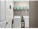 Laundry room showing stacked washer and dryer, tiled floor and storage shelves at 112 Bridgemor Ln, Mooresville, IN 46158