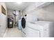 Clean laundry room featuring a washer, dryer, water heater, and storage shelving at 11835 Bengals Dr, Fishers, IN 46037