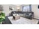 Cozy living room featuring a large sectional sofa, wood floors, and ample natural light at 11835 Bengals Dr, Fishers, IN 46037